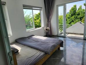 a bed in a room with a large window at Tranquil Retreat Lux Villa in HungYen Countryside in HÆ°ng YÃªn