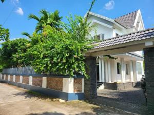 une maison avec un arbre sur son côté dans l'établissement Tranquil Retreat Lux Villa in HungYen Countryside, à HÆ°ng YÃªn 29 autres photos