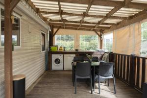 eine abgeschirmte Veranda mit einem Tisch und Stühlen in der Unterkunft Mobilhome tout équipé in Quimper