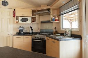 a small kitchen with a stove and a sink at Mobilhome tout équipé in Quimper