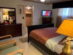 a bedroom with a bed and a television and a chair at Vacation home in Melbourne