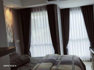 - une chambre avec un lit et 2 grandes fenêtres dans l'établissement Apartemen Skylounge Makassar, à Manda