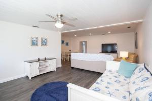 uma sala de estar com uma cama e um sofá em Bright, Immaculate and Cozy Coastal Cottage in Ozona em Palm Harbor