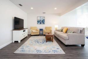 uma sala de estar com um sofá e uma televisão em Bright, Immaculate and Cozy Coastal Cottage in Ozona em Palm Harbor