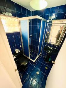 Macuto的住宿－Casa de la Playa，蓝色瓷砖浴室设有黑色厕所和水槽
