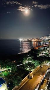 a view of a city and the ocean at night at Casa de la Playa in Macuto