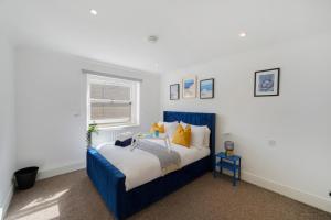 Un dormitorio con una cama azul y una ventana en LiveStay - Apartments in Bayswater London, en Londres