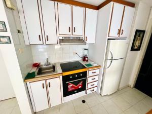 Macuto的住宿－Casa de la Playa，厨房配有白色橱柜、水槽和冰箱。