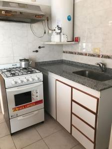 a kitchen with a stove and a sink at Depto 2 in Villa Carlos Paz