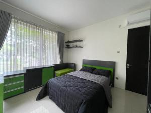 een slaapkamer met een bed en een groot raam bij Aryastri Villa in Bandung