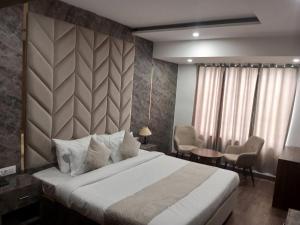 a bedroom with a large bed and a table and chairs at HOTEL NAT GRAND REGENCY LUDHIANA Punjab INDIA in Ludhiana