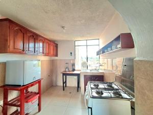 uma cozinha com armários de madeira e um forno de fogão branco em Alojamiento Comodo con Vista Espectacular em Riobamba