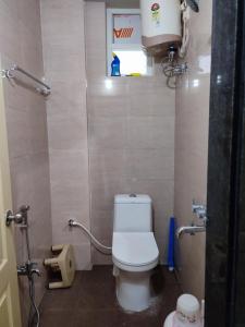 a small bathroom with a toilet in a stall at Rahul's Castle Guest House in Visakhapatnam