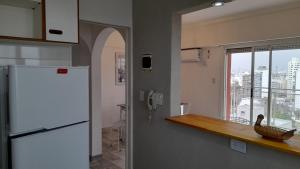 a kitchen with a white refrigerator and a window at TORRE Rivera in Buenos Aires