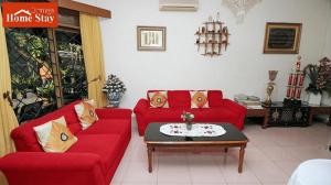 a living room with two red couches and a coffee table at Orange Home Syariah in Bandung