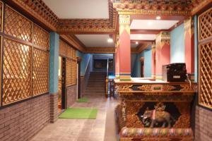 a hallway of a building with a fireplace and stairs at Hotel De Purang in Muktināth