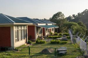 a house with solar panels on the roof at Dhauladhar View Village Resort in Dharmsāla