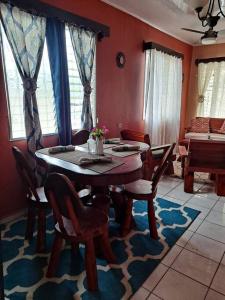 comedor con mesa de madera y sillas en 3 Bedroom & Terrace Pool, en La Ceiba