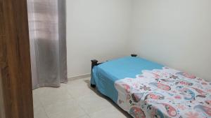 Schlafzimmer mit einem Bett mit blauer Decke in der Unterkunft Apartamento cool Neiva in Neiva