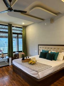 a bedroom with a large bed with bananas on it at Dhauladhar View Village Resort in Dharmsāla