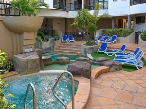 a courtyard with chairs and a pool in a building at Nautilus Resort - Private Apartment in Mooloolaba