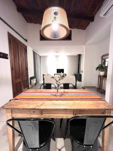 mesa de comedor con 2 sillas y lámpara en Casa Los Olivos en Nueve de Julio