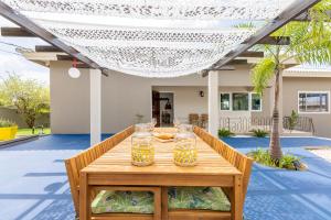 a wooden table with two glasses of whiskey on it at Familiewoning met privé zwembad in Willemstad