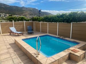 a swimming pool on a patio with a chair at Crescent Corner Vacation Home in Cape Town