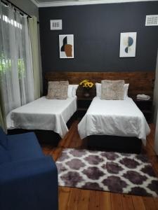 um quarto com duas camas e um tapete em Inkanyezi guest house em Durban