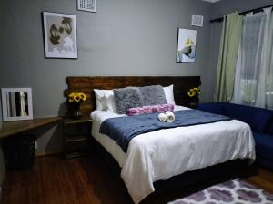 a bedroom with a bed with two stuffed animals on it at Inkanyezi guest house in Durban