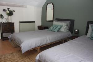a bedroom with two beds and a mirror at Fishermans Cottage built in 1705 in Hastings