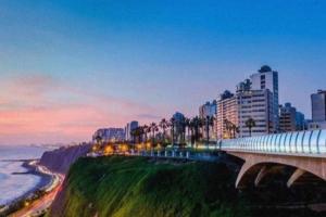a view of a city with a bridge and the ocean at Lindo amplio cerca a Larcomar in Lima