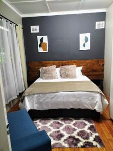 um quarto com uma cama grande e um sofá azul em Inkanyezi guest house em Durban