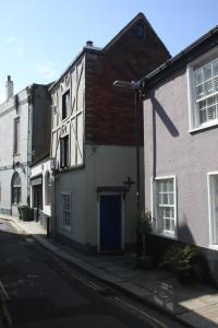 a white building with a blue door on a street at Fishermans Cottage built in 1705 in Hastings