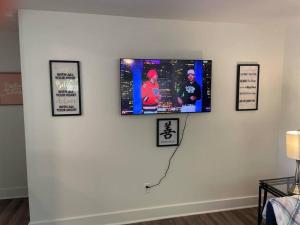 uma televisão de ecrã plano numa parede branca com fotografias em Charming 2Br, Fully Equipped kitchen, Smart TV em Greenville