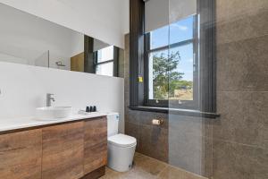 a bathroom with a toilet and a sink and a window at Costello Hotels Port Augusta in Port Augusta