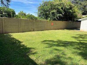 a backyard with a fence and a grass yard at Charming 2Br, Fully Equipped kitchen, Smart TV in Greenville