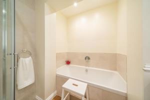 a white bathroom with a tub and a shower at Dreamy Town House Apartment in Birnam, Dunkeld in Birnam +8 photos