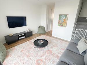 a living room with a couch and a table at Sunny Beachside Home in Orewa