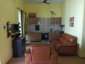 sala de estar con sofá y silla en Serene Pool Villa, en Karumattampatti