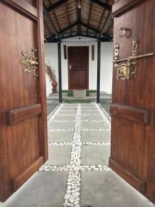 una entrada a un edificio con 2 puertas de madera en Serene Pool Villa, en Karumattampatti