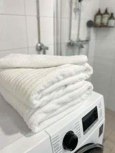 a stack of white towels sitting on top of a toaster at StyleStudio Areena1 in Tampere