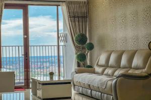 a living room with a couch and a large window at Taiping Homestay near Lake Garden with Sunset View in Taiping