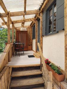 una terraza de madera con mesa y sillas en una casa en Petit studio dans la prairie en Saint-Auban