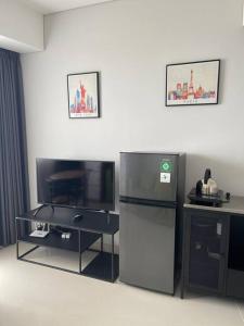una cucina con frigorifero e TV di Luxe 1-Bedroom Haven with Ocean View on the 5th Floor of Kalani Tower a Nongsa