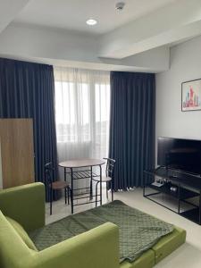 un soggiorno con divano e tavolo di Luxe 1-Bedroom Haven with Ocean View on the 5th Floor of Kalani Tower a Nongsa