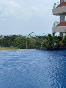 a pool of blue water in front of a building at Luxe 1-Bedroom Haven with Ocean View on the 5th Floor of Kalani Tower in Nongsa