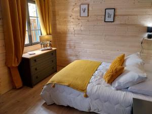 a bedroom with a bed and a wooden wall at Petit studio dans la prairie in Saint-Auban