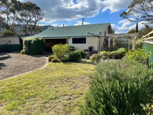 a house with a green roof and a yard at Five o'clock somewhere in Dunalley