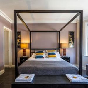 a bedroom with a large bed with a large headboard at Bournemouth Beach Boutique with Hot Tub in Bournemouth